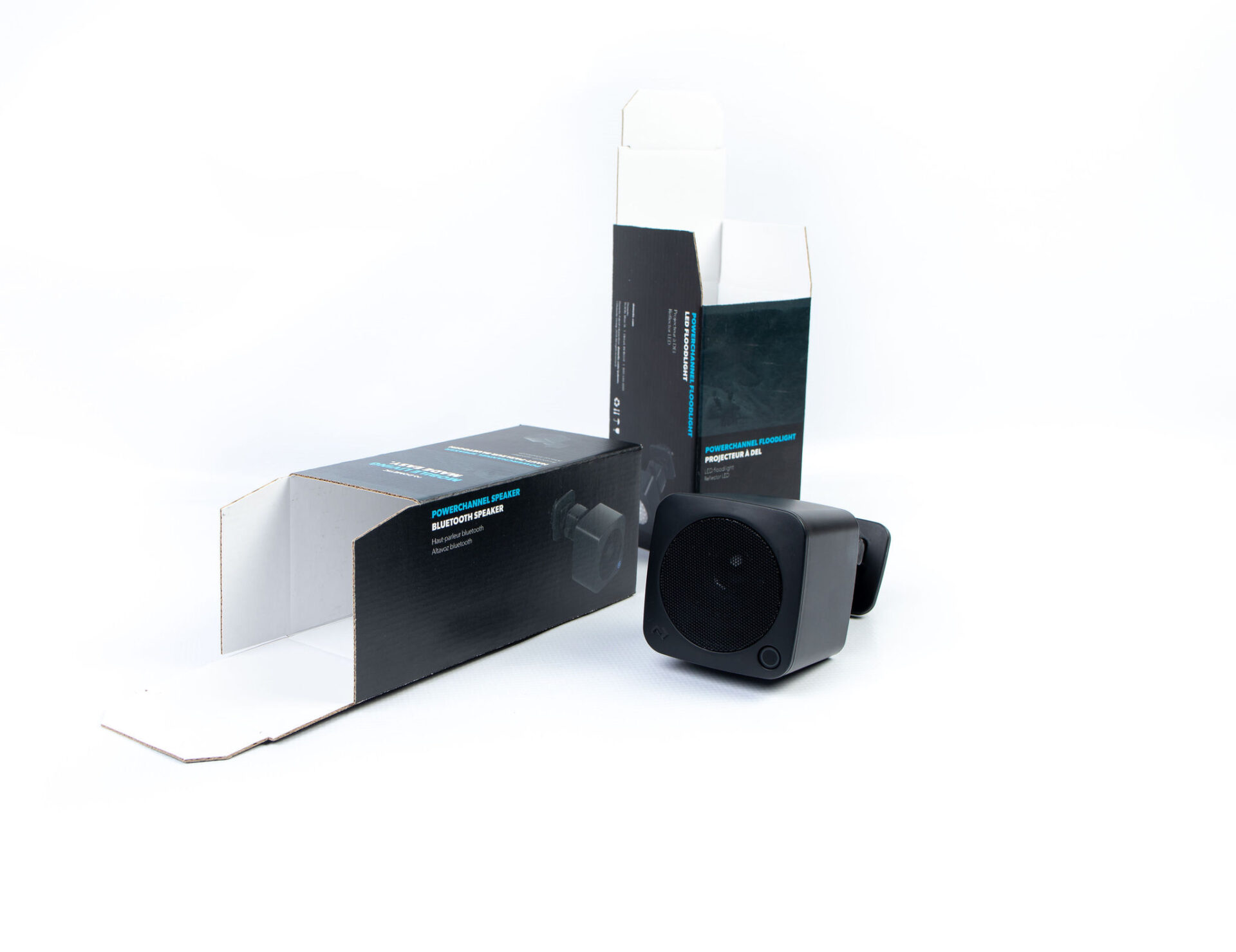 bluetooth speaker next to its cardboard packaging